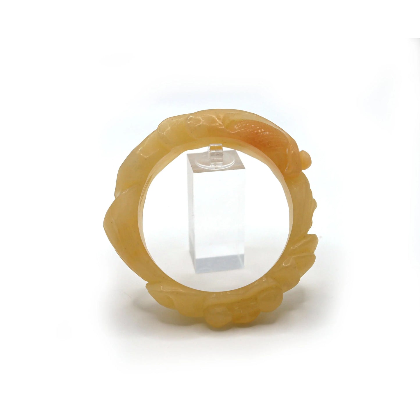 Dimensional goldfish carving set in warm yellow jade, its curves suggesting movement and prosperity amidst lotus blooms – Miruzi