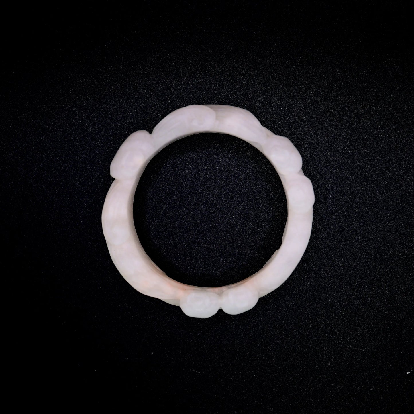 Artisan-crafted jade bracelet featuring bluebell motif and botanical floral carving