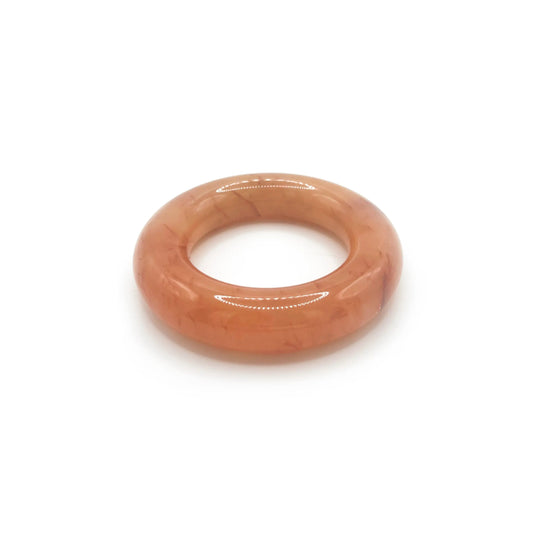 Donut bangle bracelet carved from Mongolian jade quartzite in translucent orange, featuring red petal accents and a smooth, jelly-like round silhouette. - Miruzi