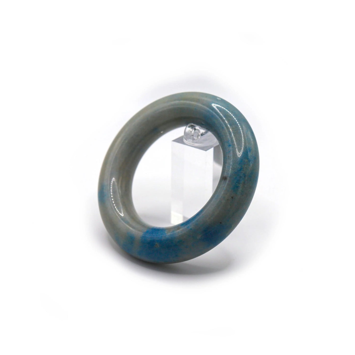 Round jade bracelet styled on pastel-toned fabric, its pale blue streaks and white base reflecting softness and modernity – Miruzi