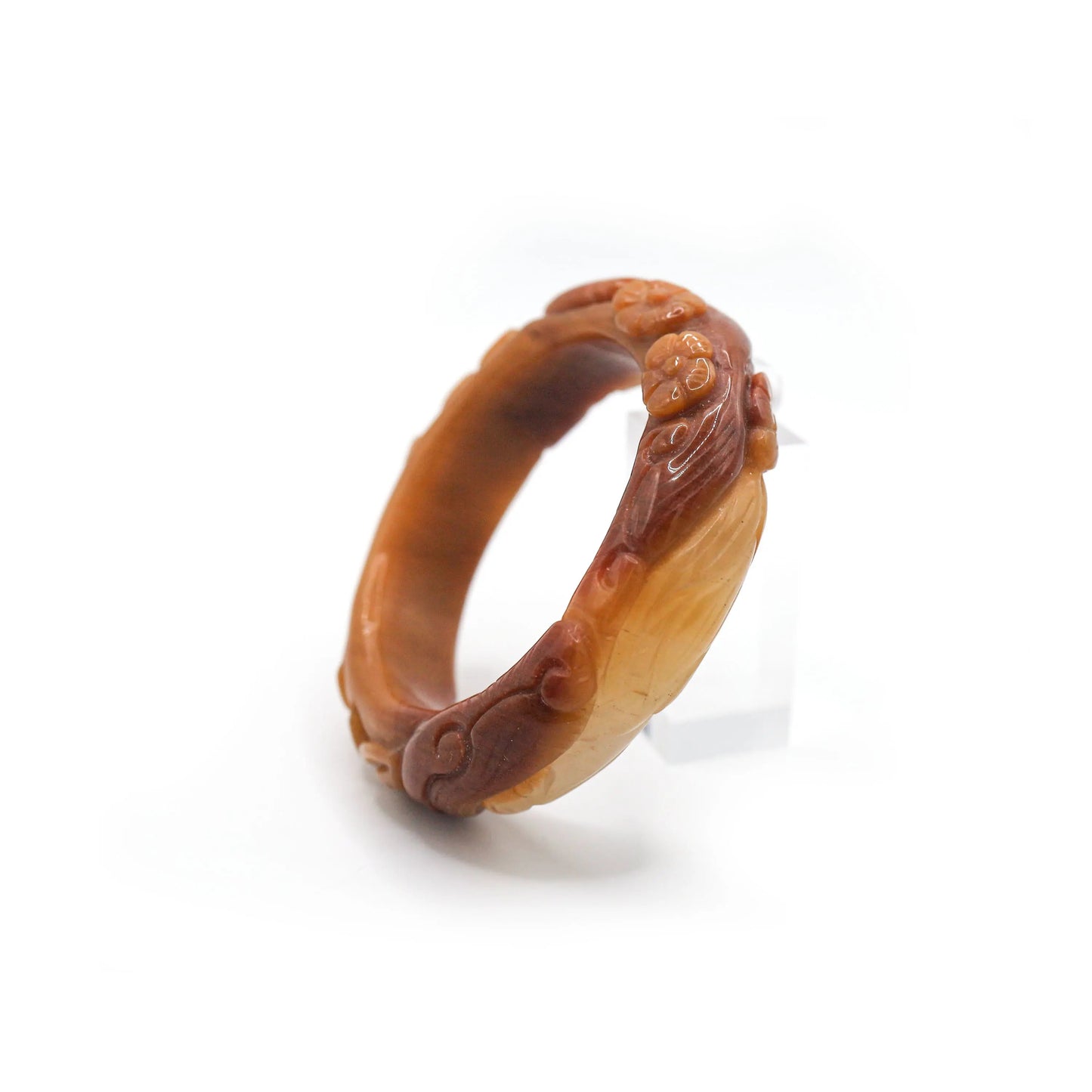 A full-relief lotus flower rises from the surface of this glowing orange jade bangle, symbolizing rebirth and elegant strength – Miruzi