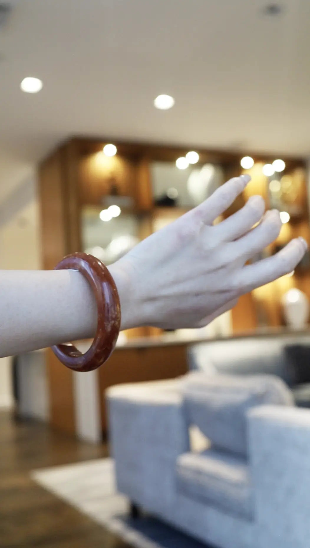 Hand-carved red serpentine jade bracelet in rich crimson with delicate golden and white veins flowing beneath the polished surface – Miruzi