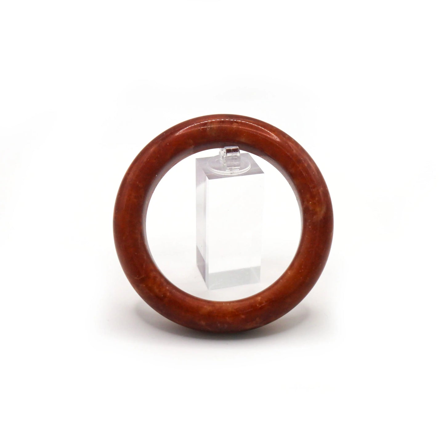 Classic round red jade bangle glowing under natural warm light