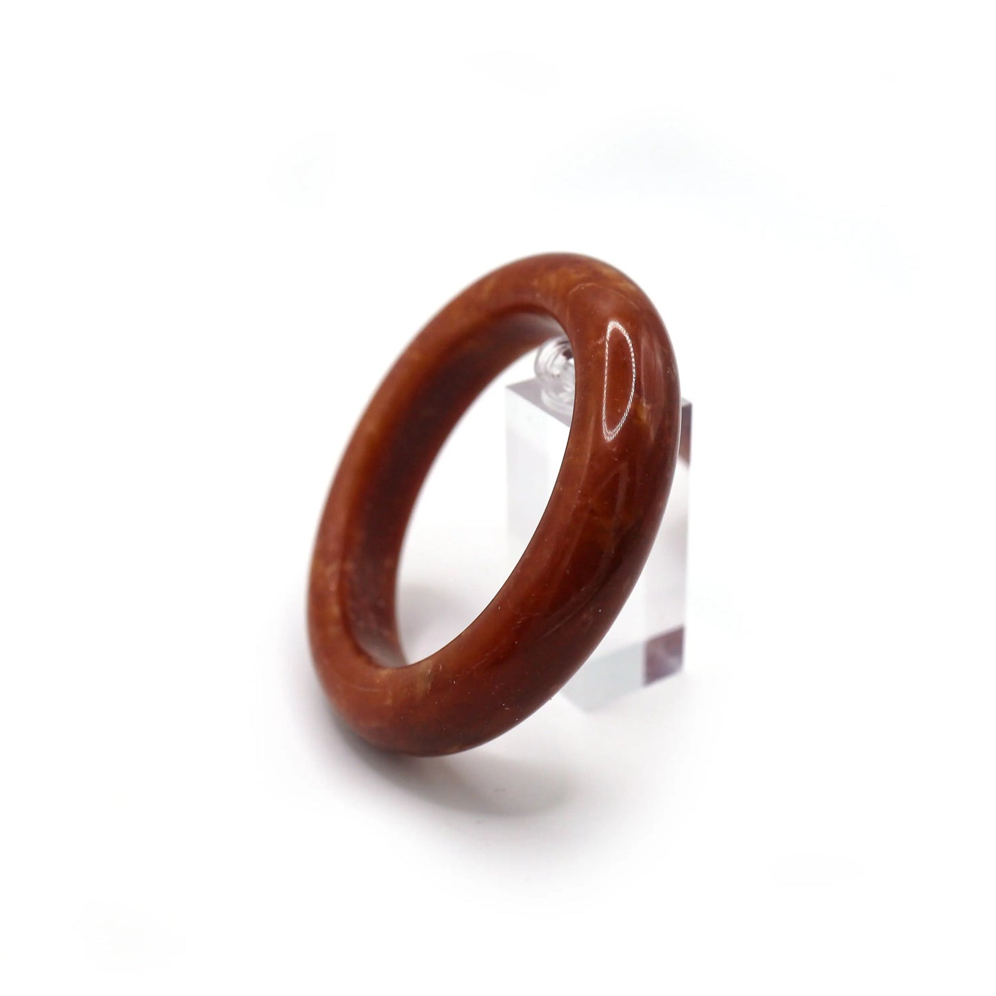 Close-up of red serpentine jade bracelet showing swirling gold and white veins