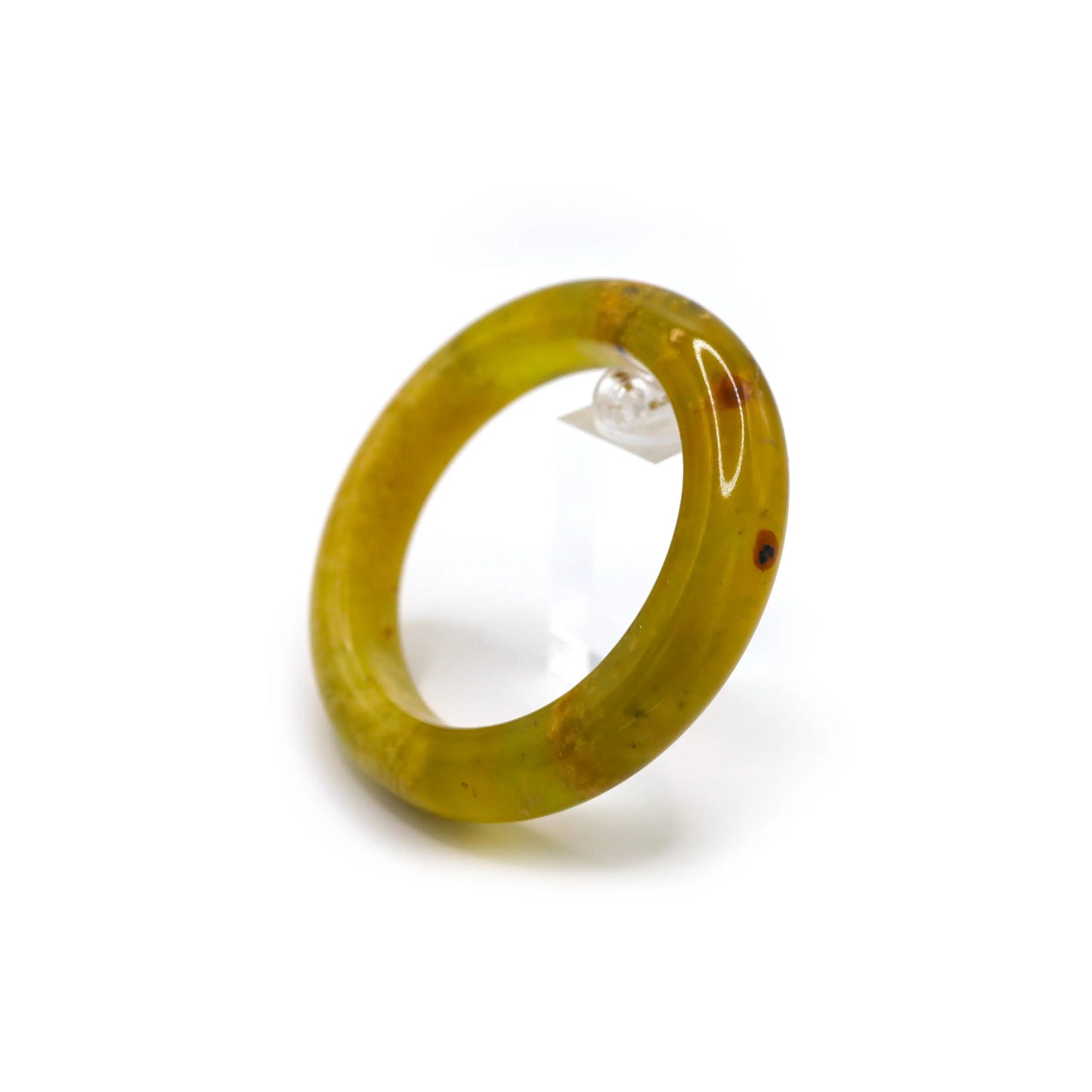 Full-circle jade bangle displayed on clean white surface, with botanical marbling gently winding through its warm translucent body. - Miruzi