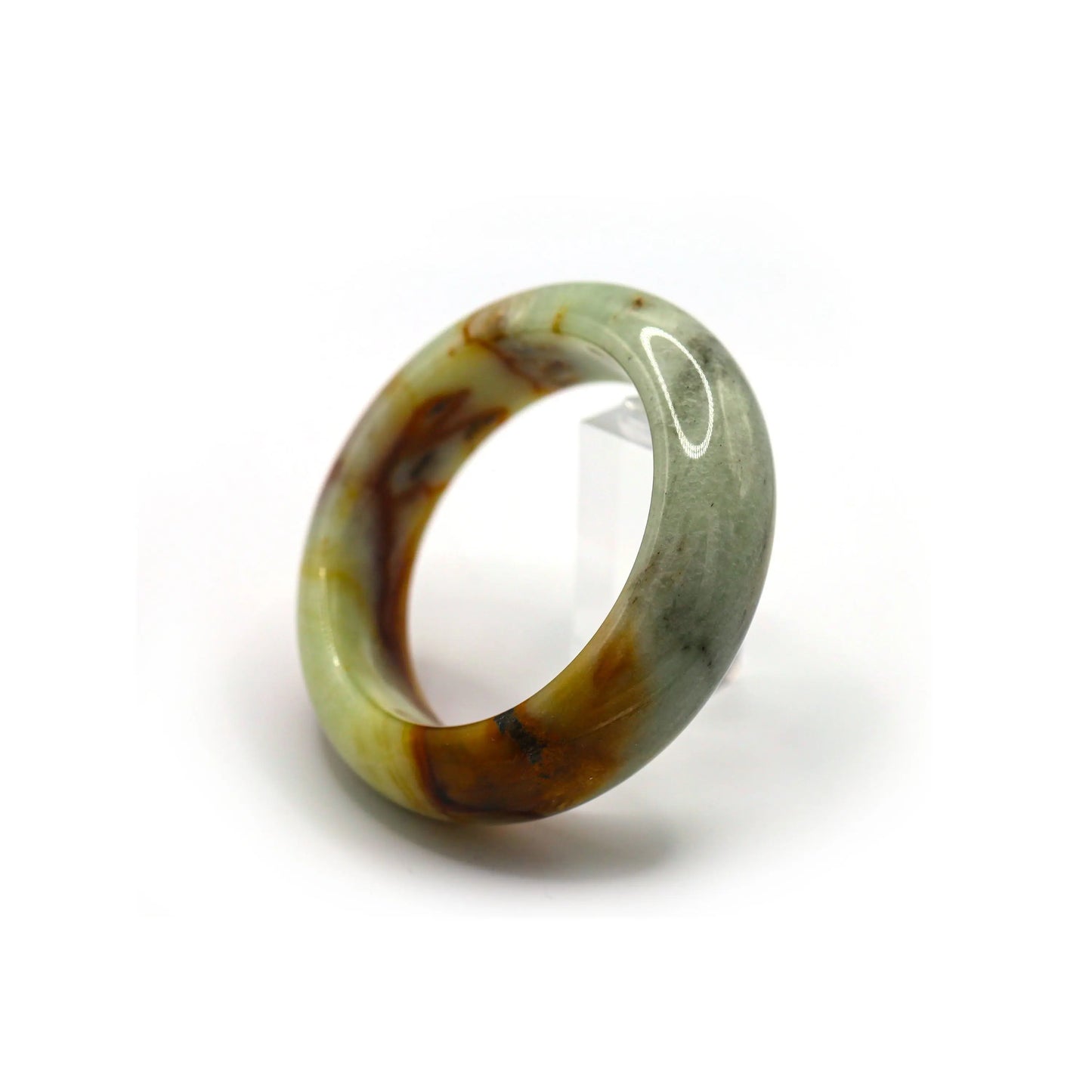 Wrist wearing green jade bangle with dramatic red inclusions, paired with simple outfit Miruzi