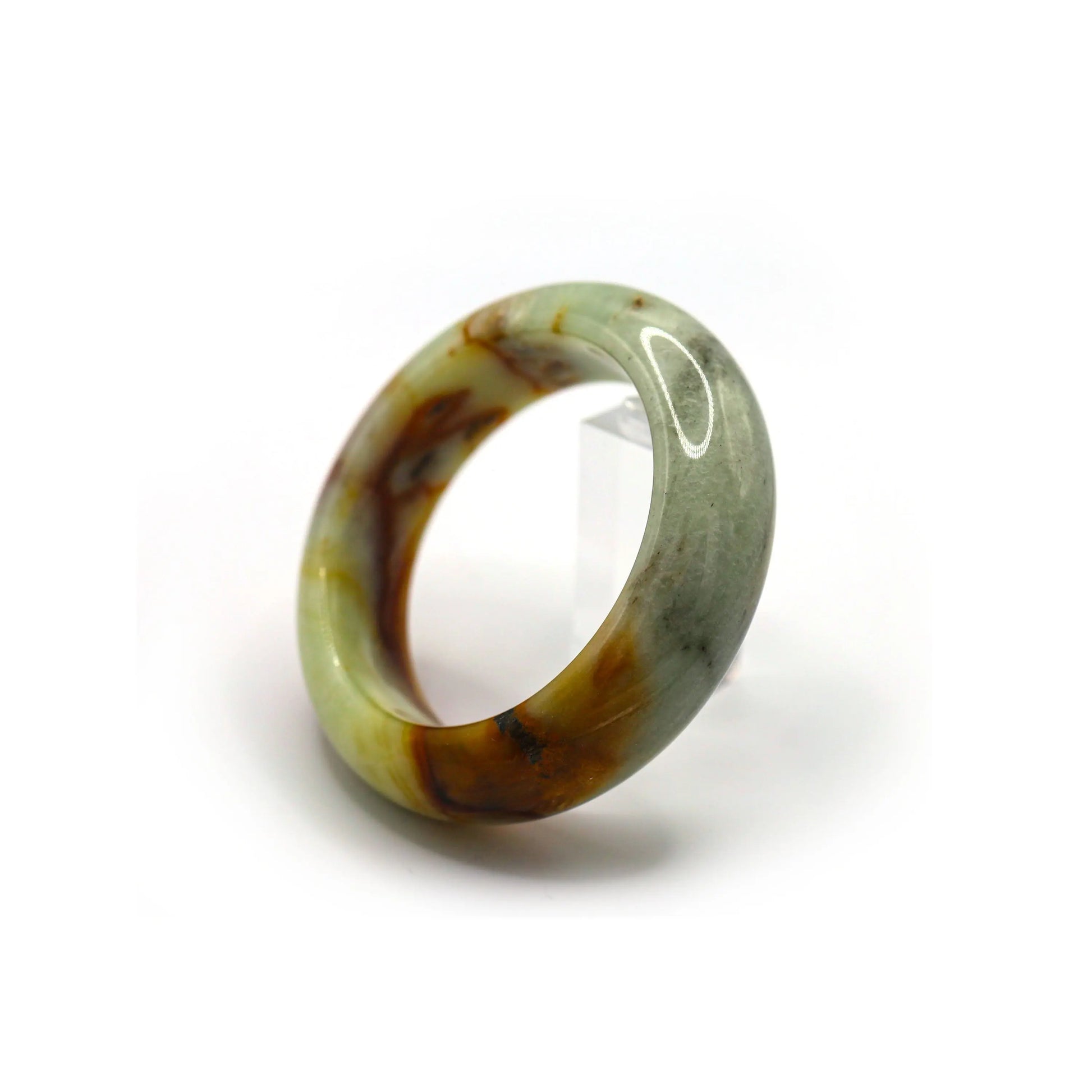 Wrist wearing green jade bangle with dramatic red inclusions, paired with simple outfit Miruzi
