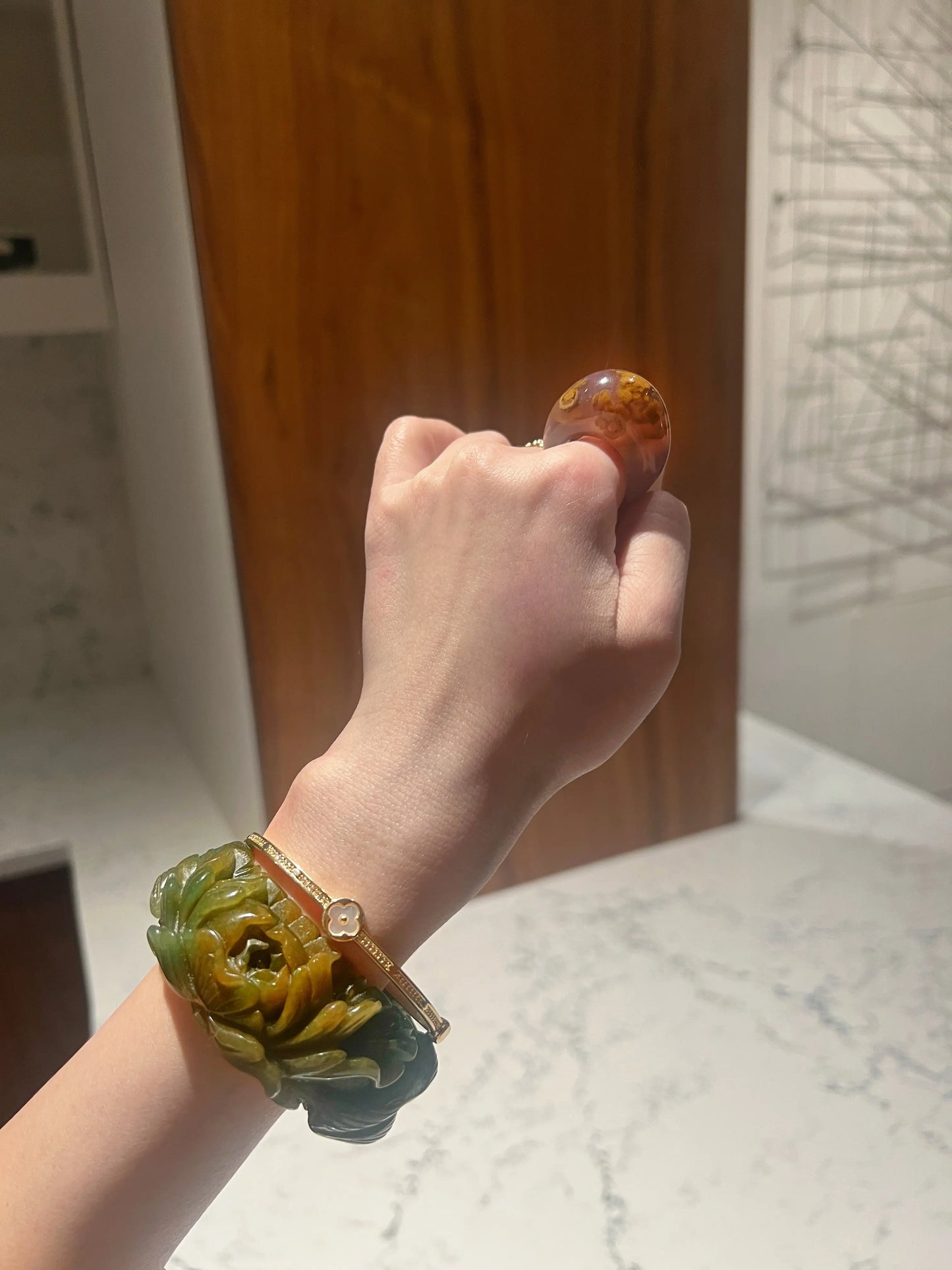 Carved jade bracelet in emerald Mongolian quartzite, featuring hand-carved peony and nine-tailed kitsune symbols with vibrant yellow detailing.