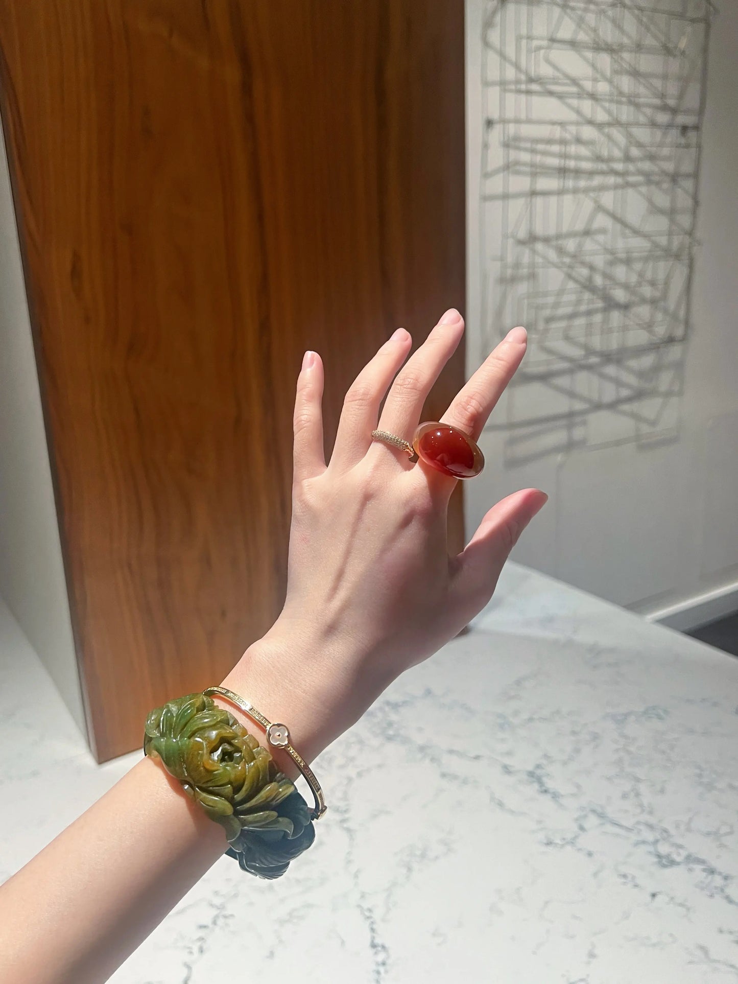 Carved jade bracelet in emerald Mongolian quartzite, featuring hand-carved peony and nine-tailed kitsune symbols with vibrant yellow detailing.