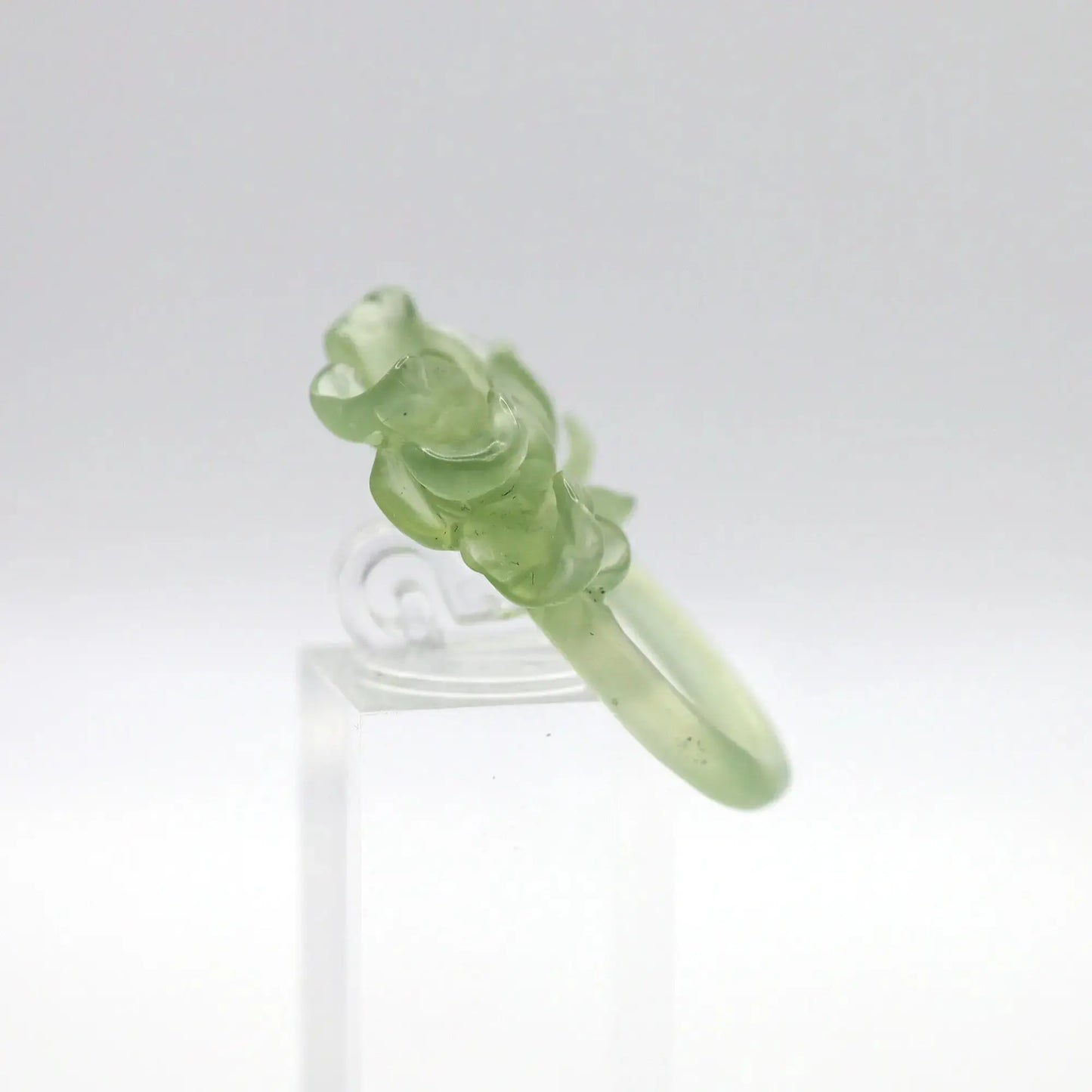 Lotus flower ring hand-carved from serpentine, featuring a soft green lotus bloom atop a clear base—symbolizing purity, peace, and artistic elegance.