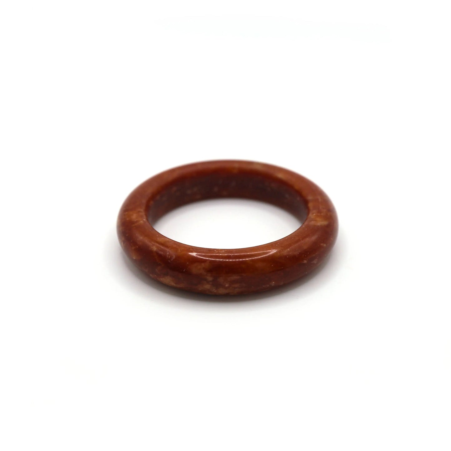 Woman wearing red jade bangle styled with neutral-toned linen outfit