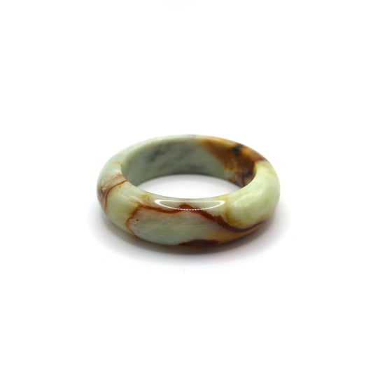 Close-up of jade bracelet showing vascular red inclusions across soft green stone Miruzi