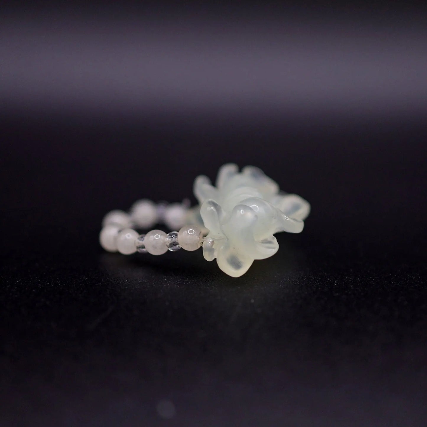 Handcrafted Serene Aqua Peony Adjustable Ring featuring a translucent, ice-clear serpentine base infused with a hint of pale aqua, showcasing a beautifully carved, three-dimensional peony. Perfect for summer, this ring combines ethereal beauty with the art of detailed craftsmanship, ideal for adding a touch of dreamy elegance to any outfit.