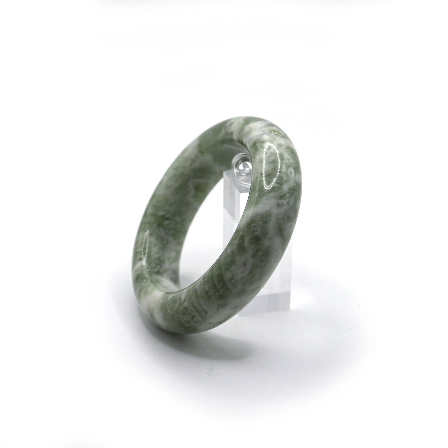 Pale green serpentine jade bracelet glowing under soft natural light - Miruzi