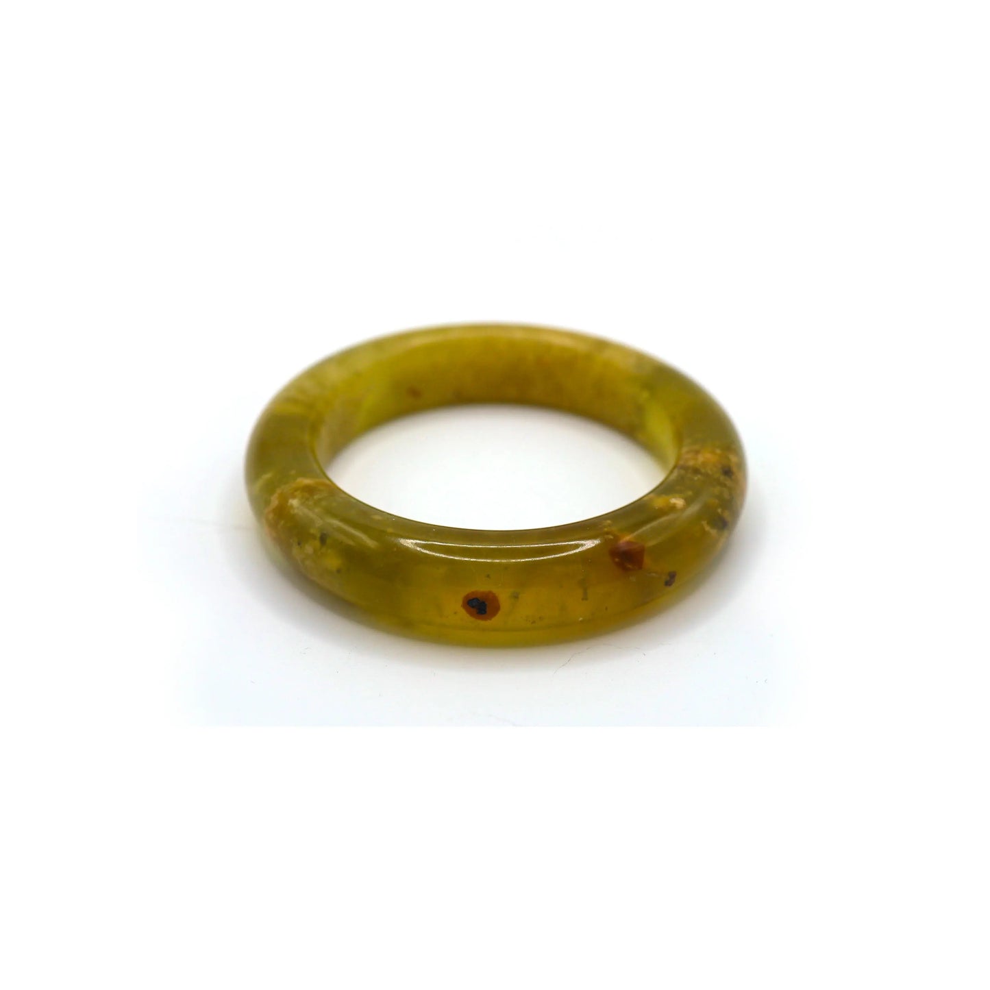 A radiant yellow jade bangle styled beside cream silk and warm cotton, emphasizing its warm tone and natural inclusions. - Miruzi