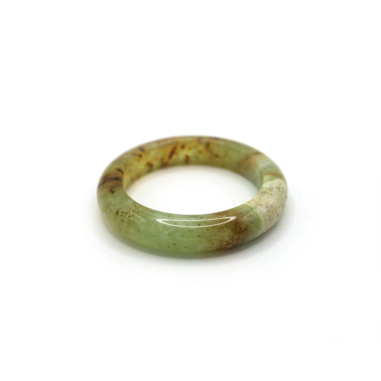 Yellow-green jade bangle glowing softly under natural warm light - miruzi