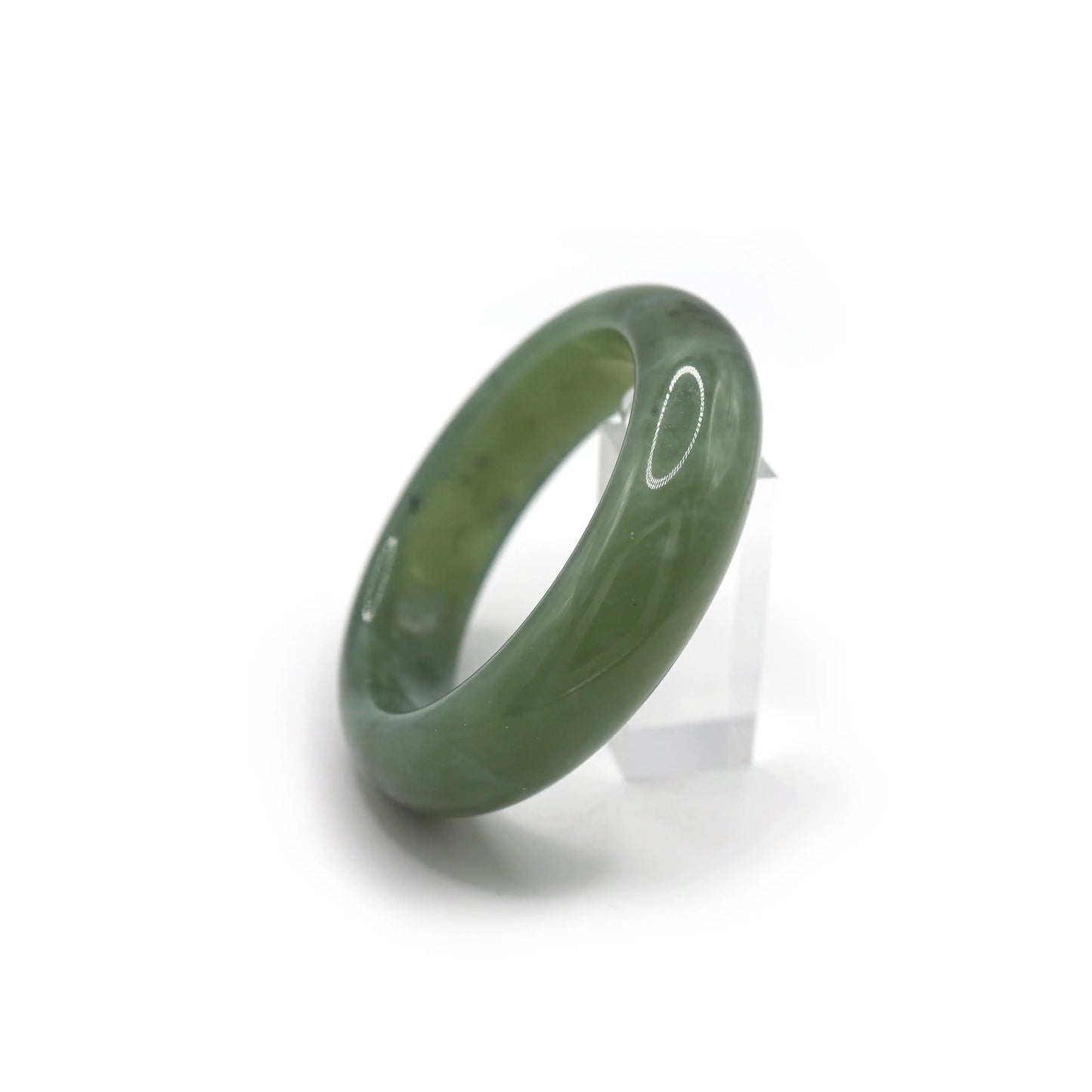 Jade bracelet glowing in natural light with hints of gold-brown and dark specks Miruzi