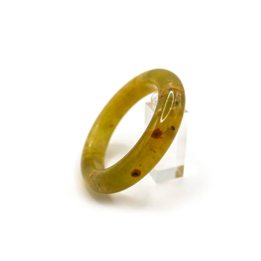 Close-up of a traditional round yellow jade bracelet with pale botanical inclusions floating through the stone like grass under clear water. - Miruzi