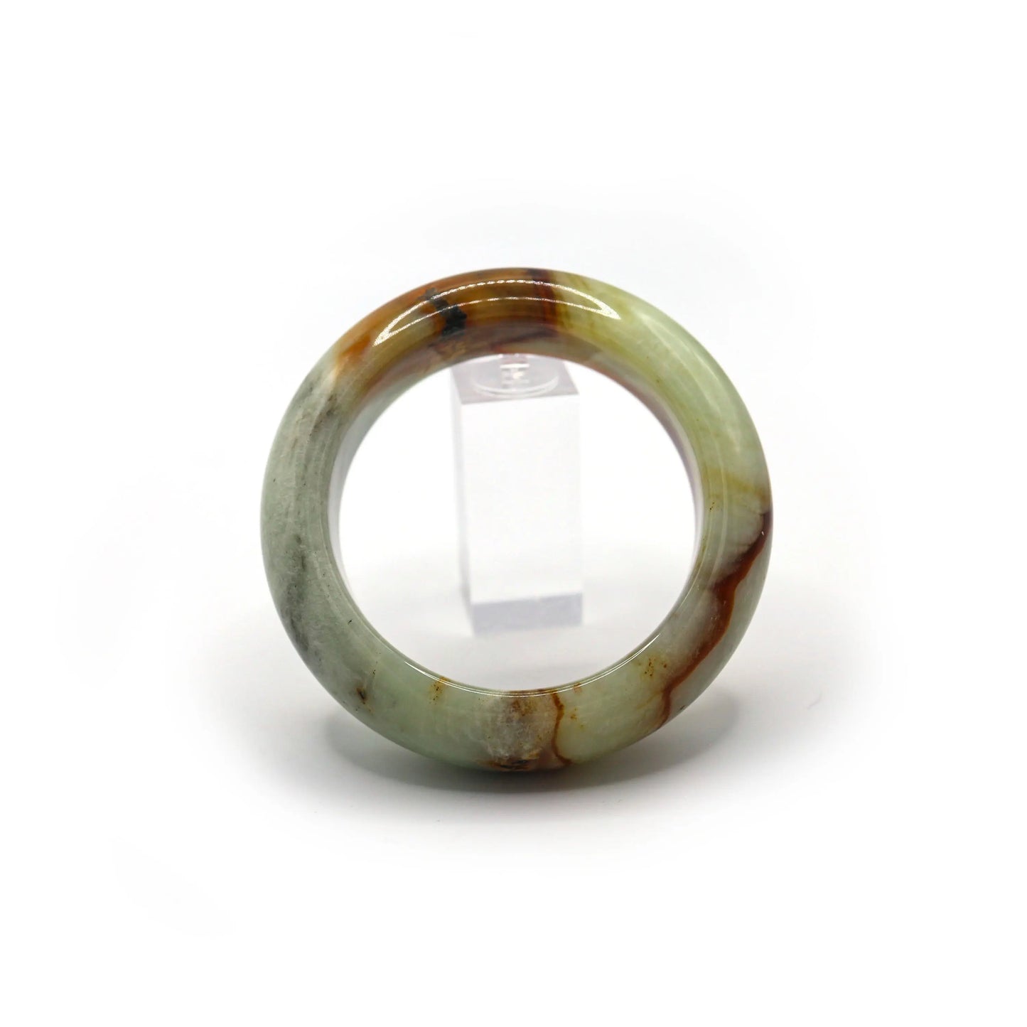 Pale green jade bangle glowing softly under light, red mineral veins clearly visible - Miruzi