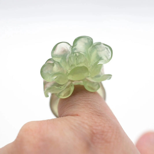 Lotus flower ring hand-carved from serpentine, featuring a soft green lotus bloom atop a clear base—symbolizing purity, peace, and artistic elegance.