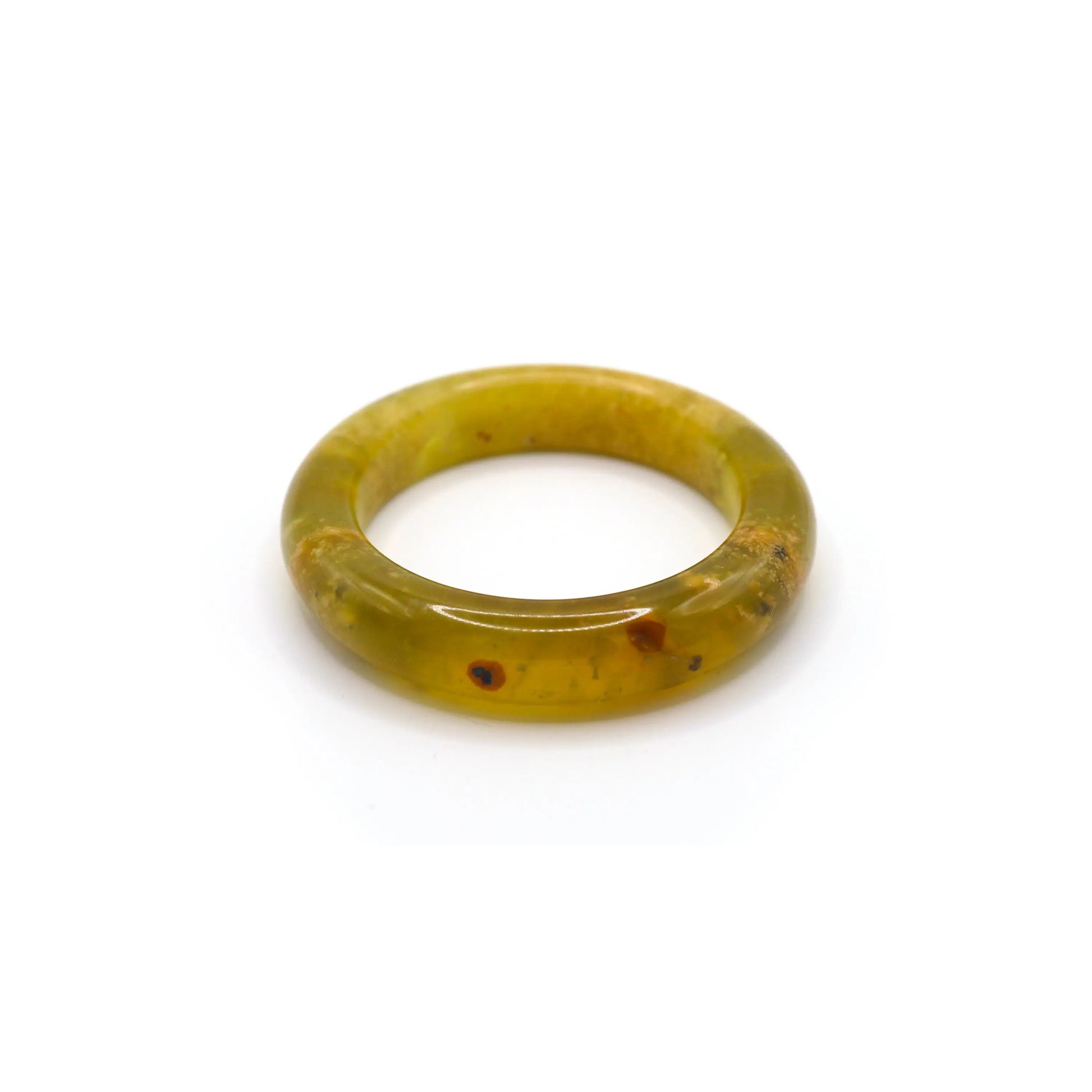 A delicate yellow jade bangle with ice-clear translucence and soft organic veining, styled on natural linen for an elegant presentation. -  Miruzi