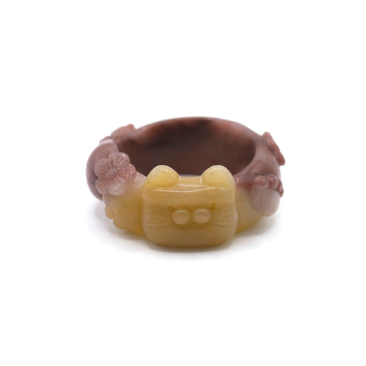Hand-carved Mongolian jade bracelet with golden yellow and lavender hues, featuring a sculpted cat face, paws, tail, and floral accents in high relief – Miruzi