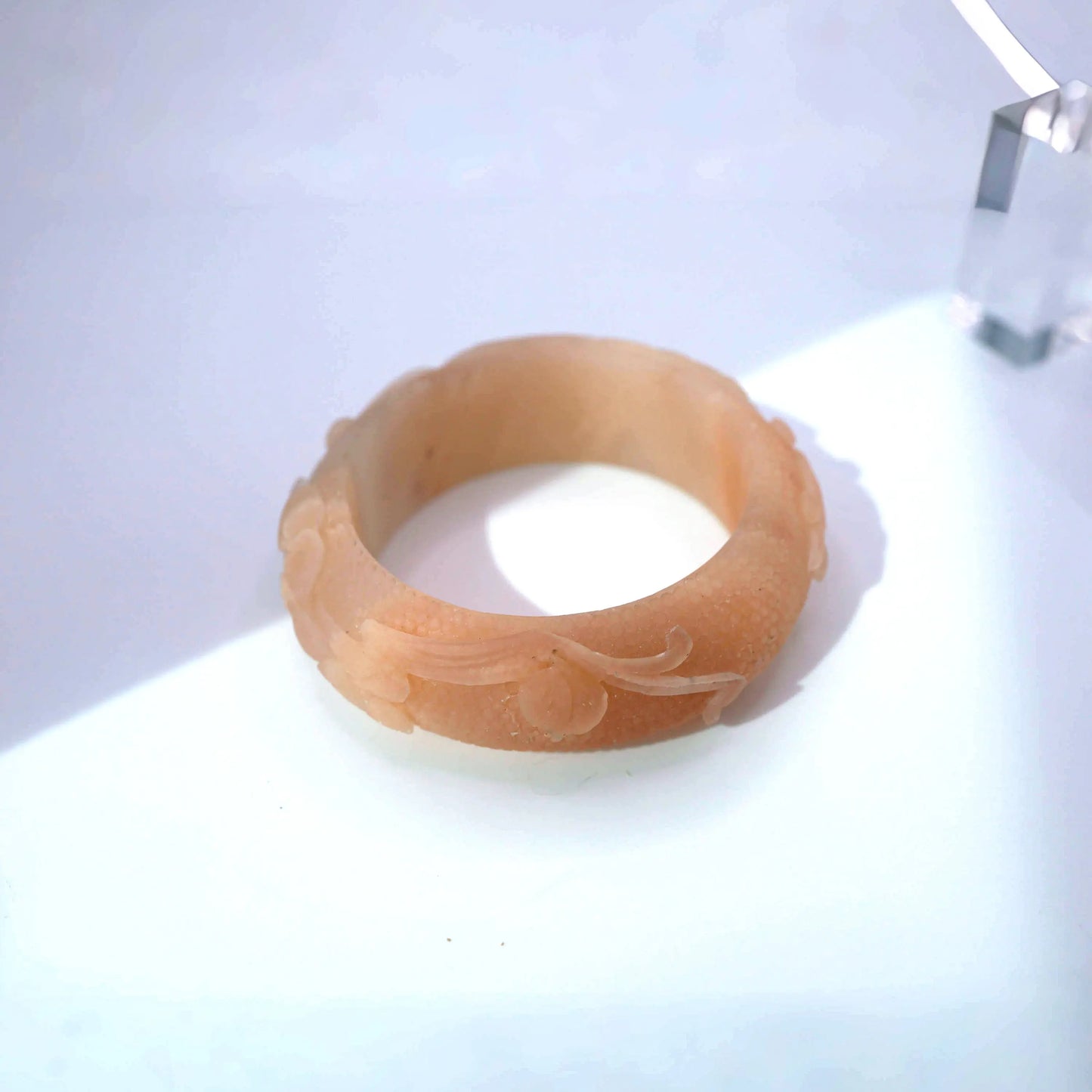 Hand-carved peach jade bangle with lotus leaf carving in wide band design, made from Mongolian stone
