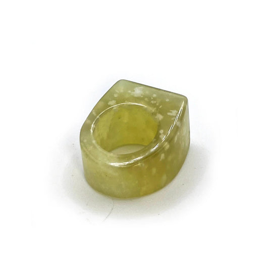 Statement jade ring carved from lemon yellow serpentine with white specks, featuring a translucent design inspired by snowstorms and nature’s quiet intensity.