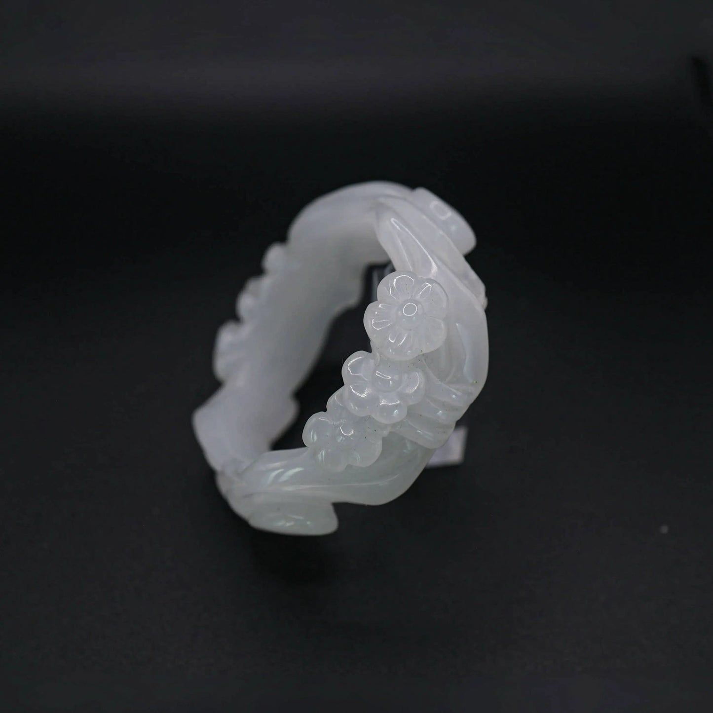 Translucent white Mongolian jade bracelet featuring symmetrical floral carving of three plum blossoms