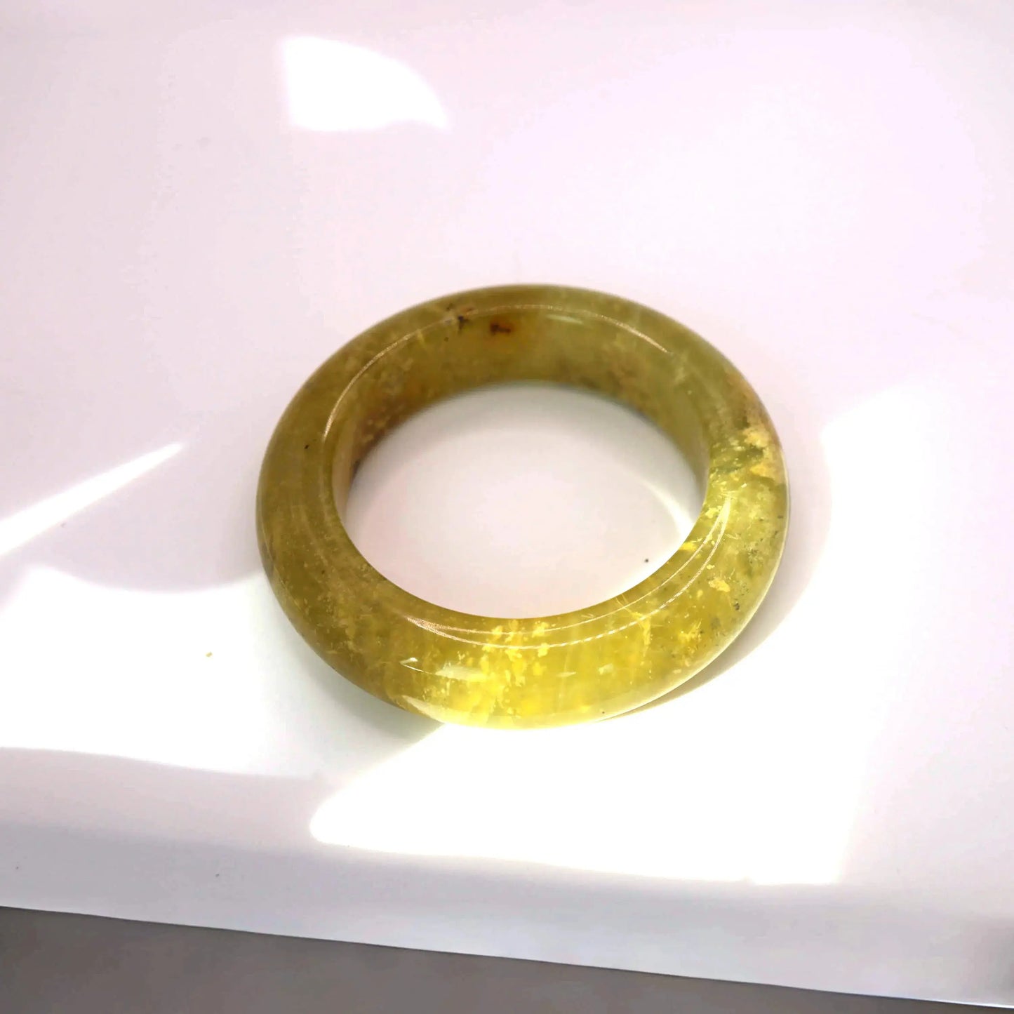 Nature-inspired golden jade jewelry piece with soft light and movement in organic mineral patterns