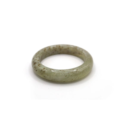 Lightweight jade bracelet featuring subtle botanical flecks within a translucent stone, styled with botanical-toned fabrics – Miruzi