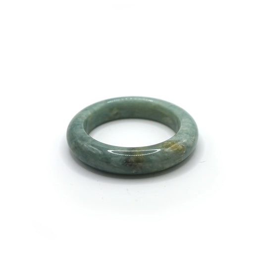 Pale blue jade bangle with subtle white and yellow veining on neutral linen - Miruzi