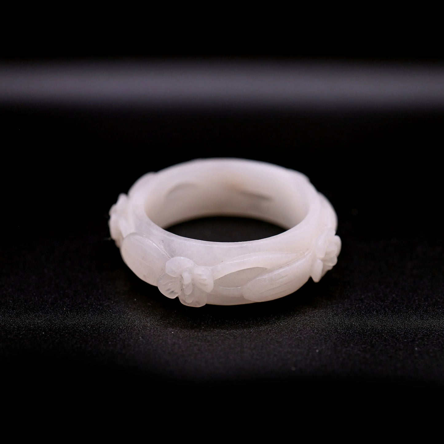 Artisan bracelet in milky white jade with floral cutouts arranged across the band, highlighting a balance of texture and negative space – Miruzi