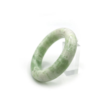 Close-up of soft green jade bracelet showing cloudy white swirls across surface - Miruzi