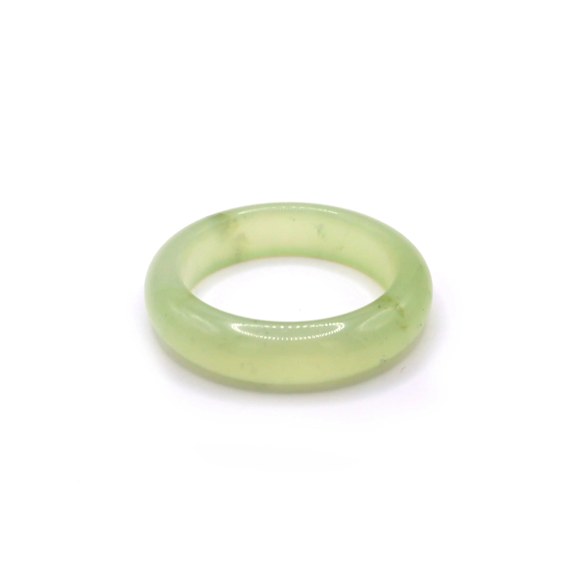 Pale green jade bracelet with jelly-like clarity and a soft mint tone, resting on light fabric to highlight its luminous translucence – Miruzi