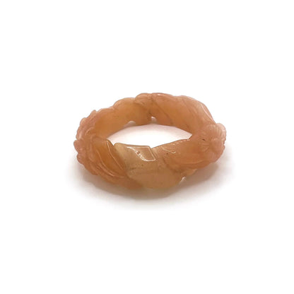 Twisted orange jade daisy bangle bracelet, showcasing a radiant blend of amber and blush tones in a playful, nature-inspired design.