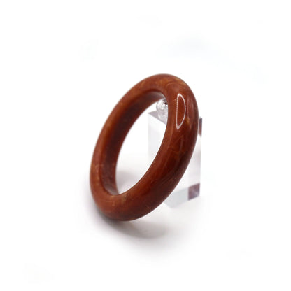 Close-up of red serpentine jade bracelet showing swirling gold and white veins