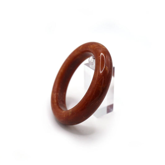 Close-up of red serpentine jade bracelet showing swirling gold and white veins
