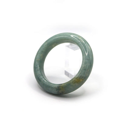 Side view of jade bracelet showing scattered flecks of white and yellow Miruzi