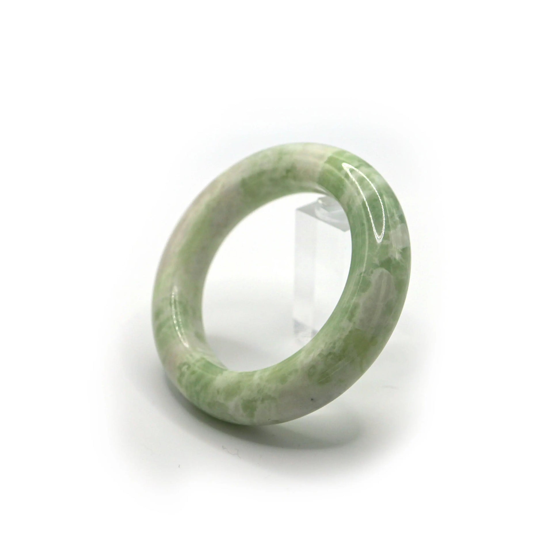 Green jade bangle resting in a soft pouch for elegant presentation and storage Miruzi