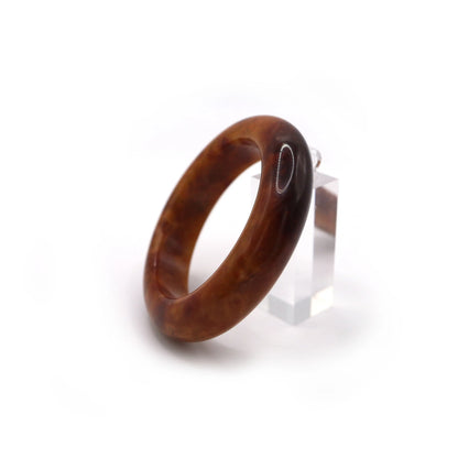 Red jade bracelet glowing under sunlight, highlighting its deep color and texture Miruzi