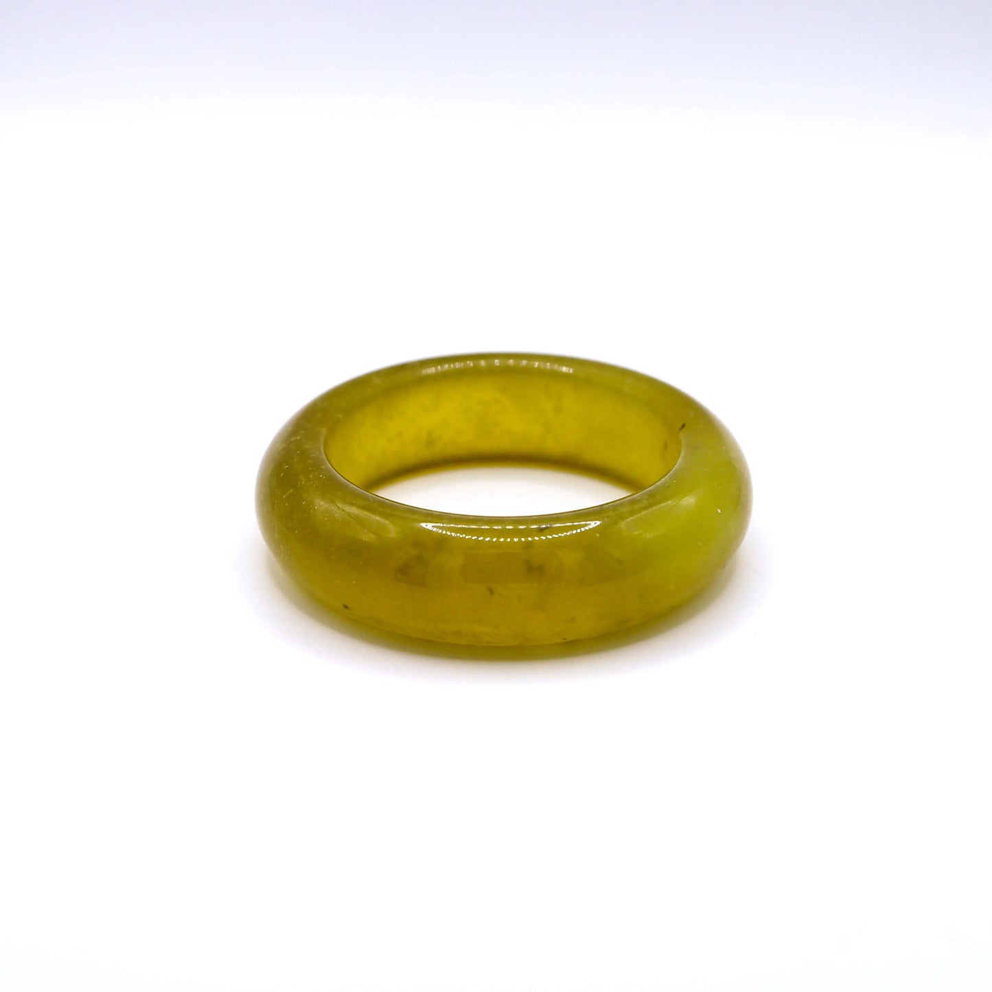 Hand-polished serpentine jade bangle in rich golden tones, showing air bubbles as natural internal inclusions. Miruzi