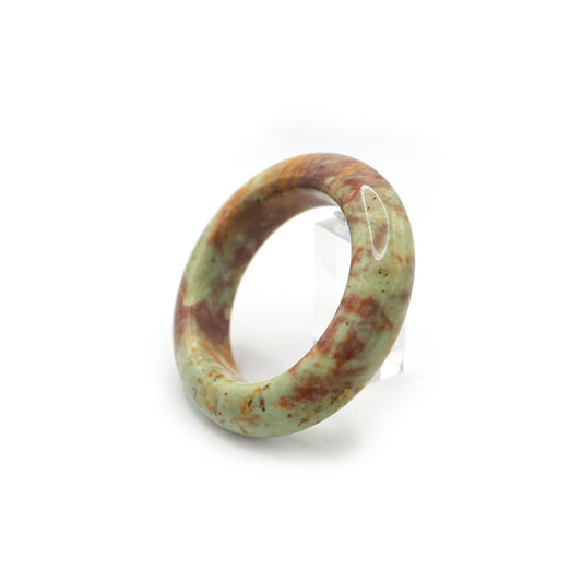Close-up of natural jade bracelet showing marbled mineral color layers - Miruzi