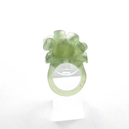 Lotus flower ring hand-carved from serpentine, featuring a soft green lotus bloom atop a clear base—symbolizing purity, peace, and artistic elegance.