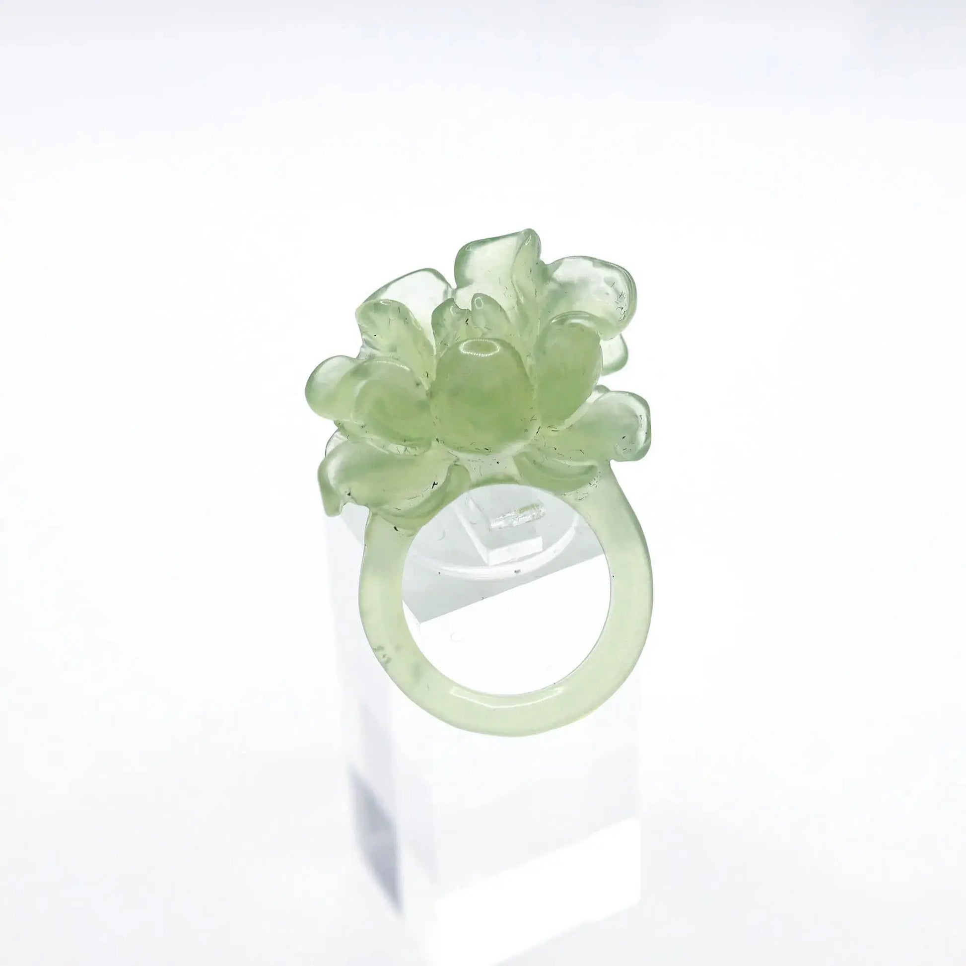 Lotus flower ring hand-carved from serpentine, featuring a soft green lotus bloom atop a clear base—symbolizing purity, peace, and artistic elegance.