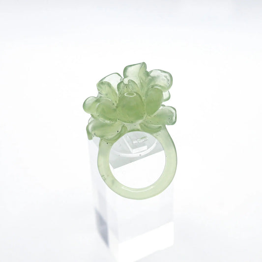Lotus flower ring hand-carved from serpentine, featuring a soft green lotus bloom atop a clear base—symbolizing purity, peace, and artistic elegance.