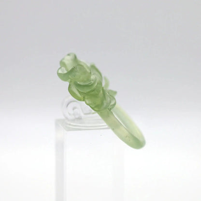 Lotus flower ring hand-carved from serpentine, featuring a soft green lotus bloom atop a clear base—symbolizing purity, peace, and artistic elegance.