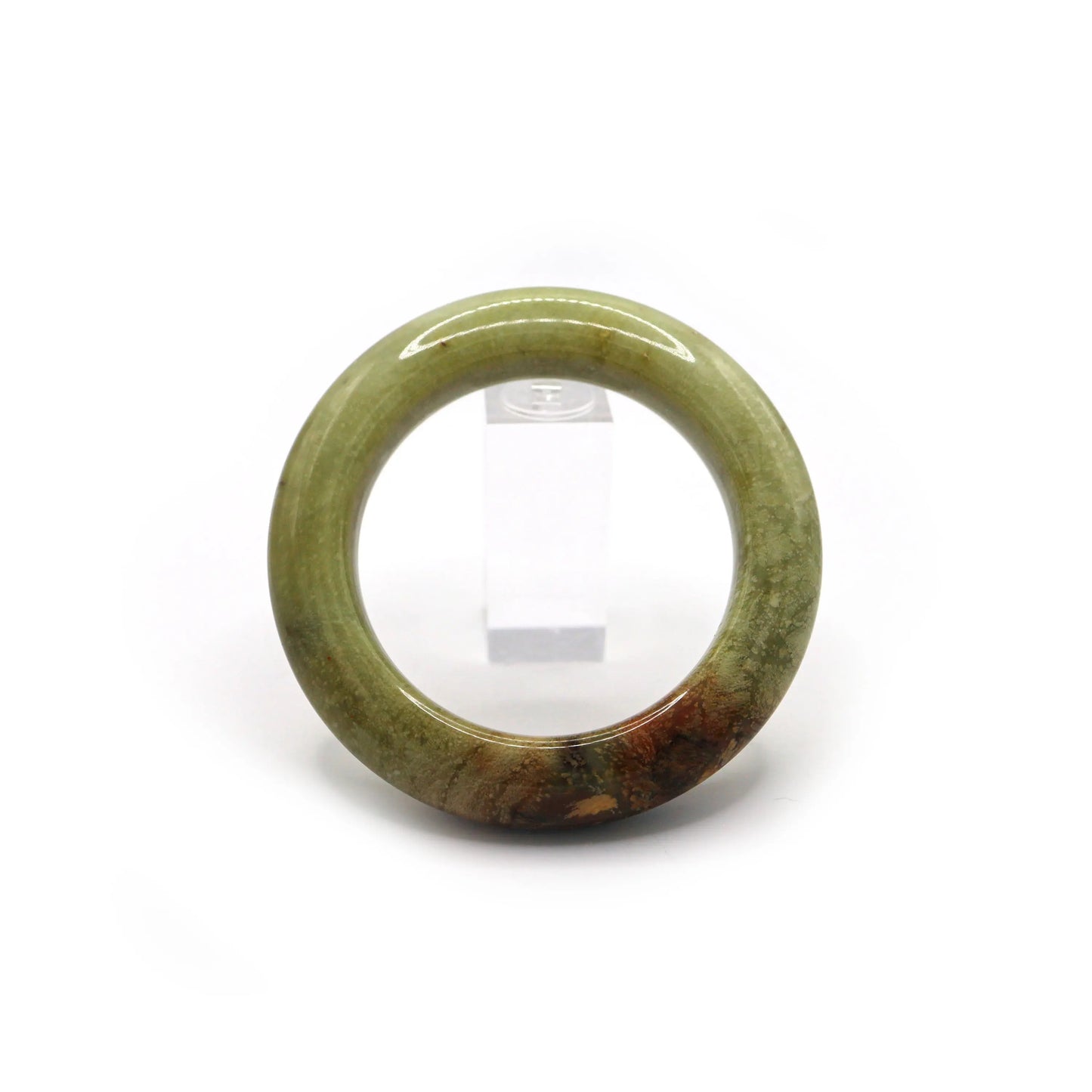 Green jade bangle placed in soft pouch showing red-brown detail zone Miruzi