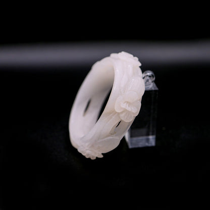 Elegant white jade bracelet with five cutout blossoms symbolizing innocence and gentle growth in wearable sculpture form – Miruzi