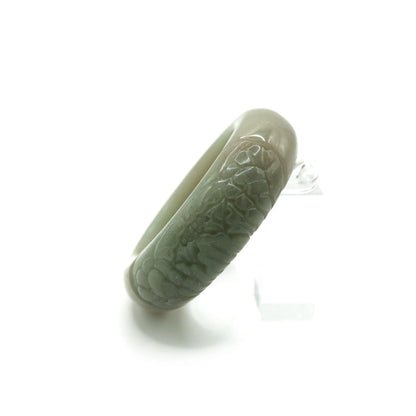 Elegant green jade bangle carved with a single peony flower, showcasing quiet refinement and natural harmony in asymmetry – Miruzi